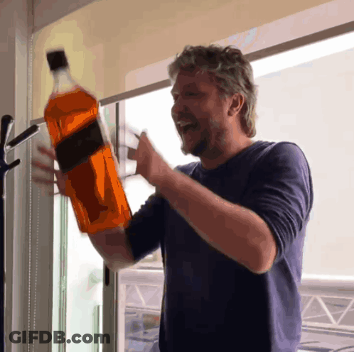 Man In Blue Shirt Holding Whiskey Bottle GIF