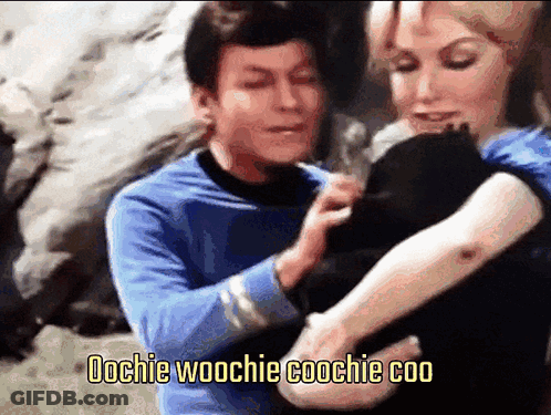 Man In Blue Shirt Holding Woman's Arm Saying Oochie Woochie Coochie Coo GIF