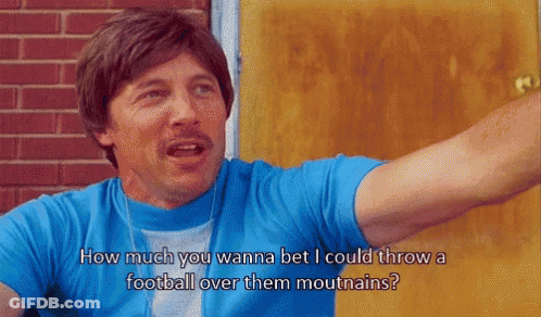 Man In Blue Shirt How Much You Wanna Bet I Could Throw A Football Over Them Mouthains GIF