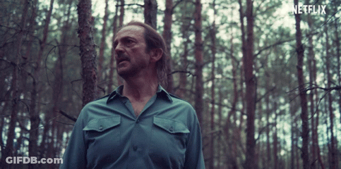 Man In Blue Shirt In Forest With Netflix Logo GIF