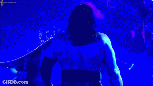 Man In Blue Shirt In Front Of Blue Light GIF