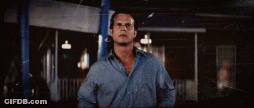 Man In Blue Shirt In Front Of Building GIF