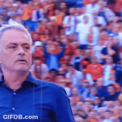 Man In Blue Shirt In Front Of Crowd GIF