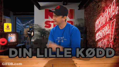 Man In Blue Shirt In Front Of Din Lille Kodd Sign GIF