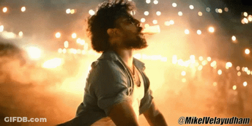 Man In Blue Shirt In Front Of Fireworks GIF