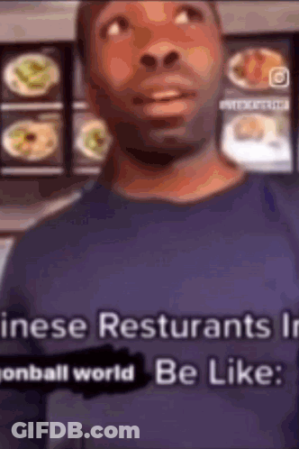 Man In Blue Shirt In Front Of Food Display GIF