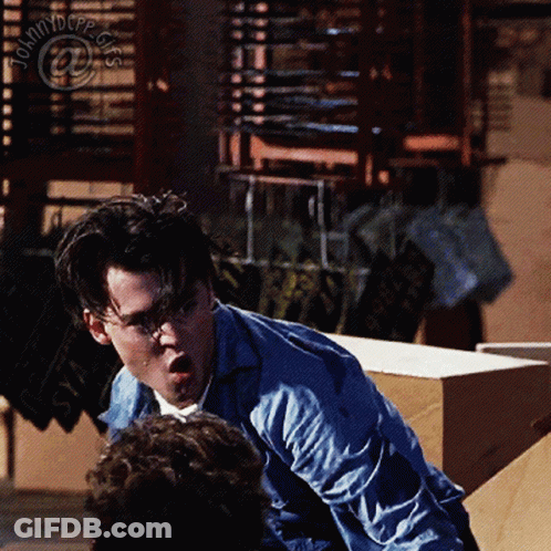 Man In Blue Shirt In Front Of Johnny Depp Sign GIF
