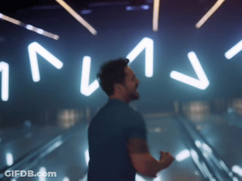 Man In Blue Shirt In Front Of NV Sign GIF