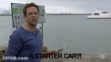 Man In Blue Shirt In Front Of Starter Car Sign GIF