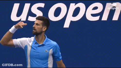 Man In Blue Shirt In Front Of US Open Sign GIF