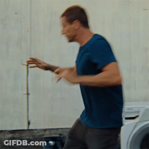 Man In Blue Shirt In Front Of Washing Machine GIF