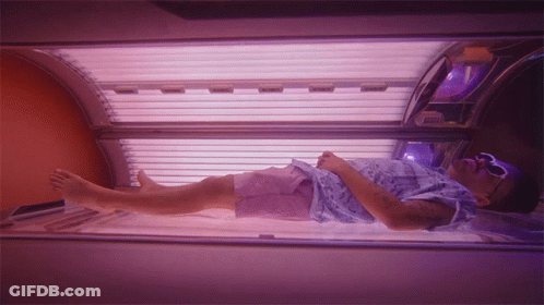 Man In Blue Shirt In Tanning Bed GIF