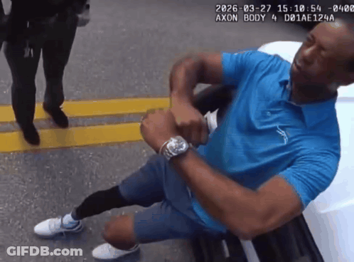Man In Blue Shirt Kneeling In Front Of White Car GIF
