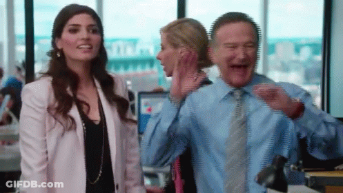 Man In Blue Shirt Laughing Next To Woman In White Jacket GIF
