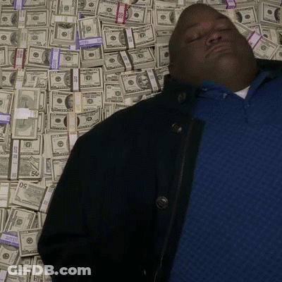 Man In Blue Shirt Laying In Pile Of Money With 50 Bill GIF