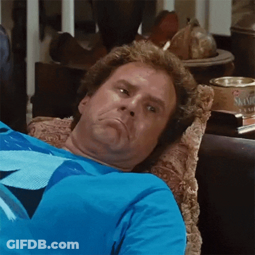 Man In Blue Shirt Laying On Couch Making Face GIF