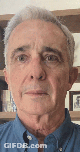 Man In Blue Shirt Looking At Camera GIF