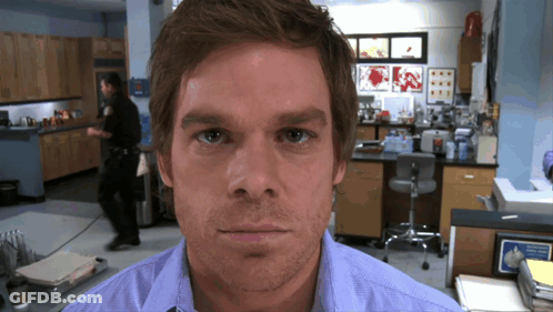 Man In Blue Shirt Looking At Camera GIF