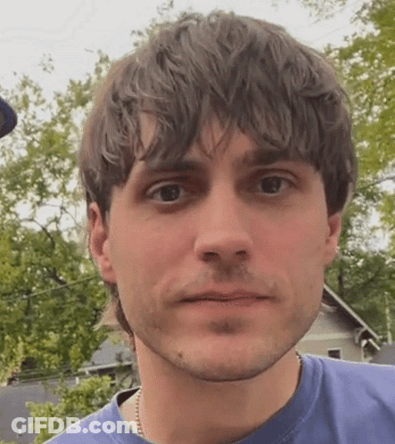 Man In Blue Shirt Looking At Camera GIF