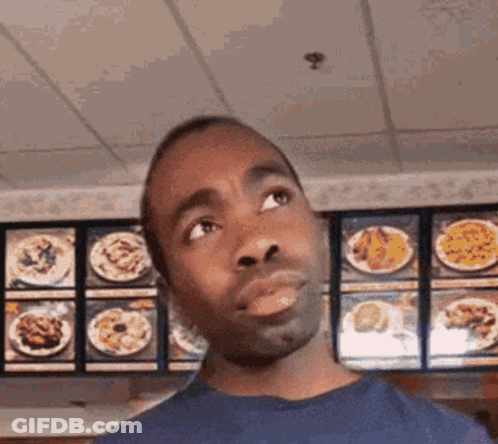 Man In Blue Shirt Looking At Menu GIF
