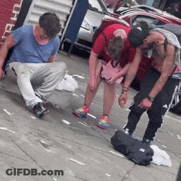 Man In Blue Shirt Looking Down On Sidewalk GIF