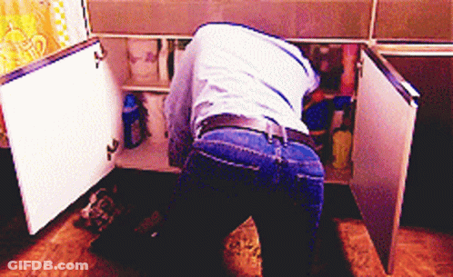 Man In Blue Shirt Looking Under Sink GIF