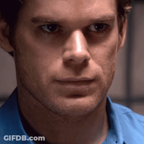 Man In Blue Shirt Looks At Camera GIF