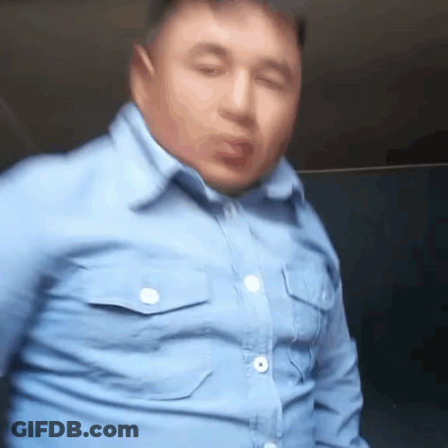 Man In Blue Shirt Making Funny Face At Window GIF