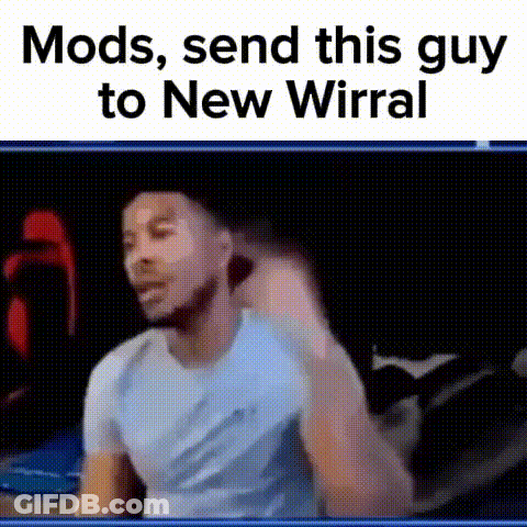 Man In Blue Shirt Making Funny Face Sitting On Bed GIF