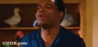 Man In Blue Shirt Making Funny Face With Duck On Shelf GIF