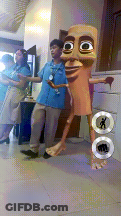 Man In Blue Shirt Next To Cartoon Character With Fist On Floor GIF