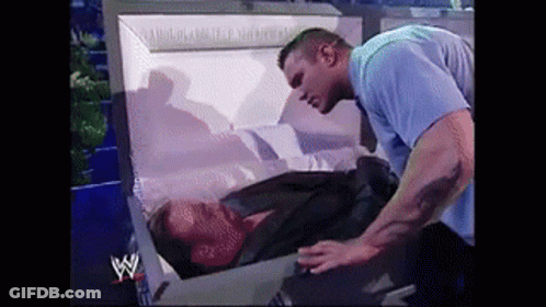 Man In Blue Shirt Next To Coffin GIF