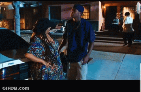 Man In Blue Shirt Next To Woman In Colorful Dress GIF