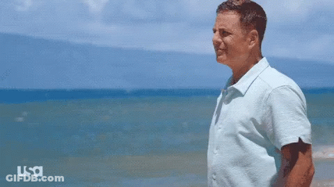 Man In Blue Shirt On Beach With USA Logo GIF