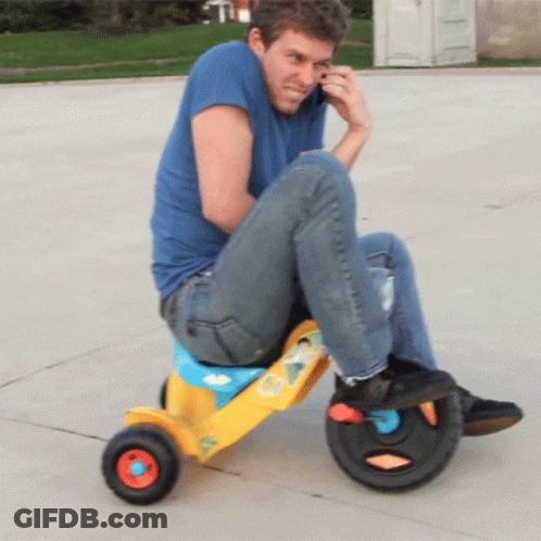 Man In Blue Shirt On Yellow Tricycle GIF