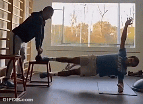 Man In Blue Shirt Planking, Another Holding Dumbbell GIF