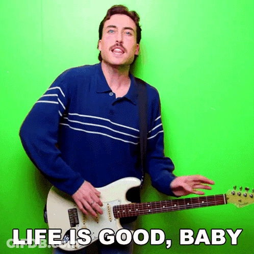 Man In Blue Shirt Playing Guitar Saying Life Is Good Baby GIF