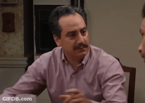 Man In Blue Shirt Pointing At Bulletin Board GIF