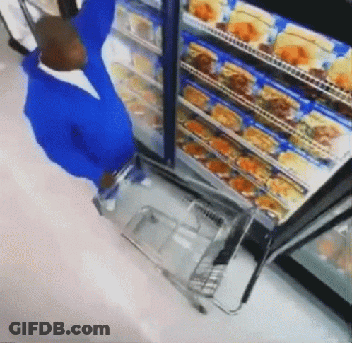 Man In Blue Shirt Pushing Shopping Cart In Store GIF
