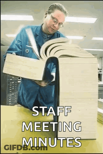 Man In Blue Shirt Reading Large Book Saying Staff Meeting Minutes GIF