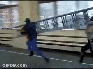 Man In Blue Shirt Running Down Street With Stairs GIF