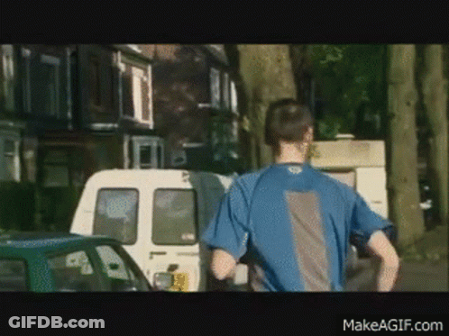 Man In Blue Shirt Running Down Street With Van GIF