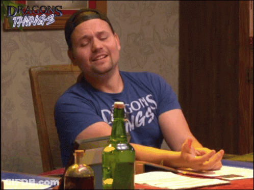 Man In Blue Shirt Saying Dragons Things Sits At Table GIF