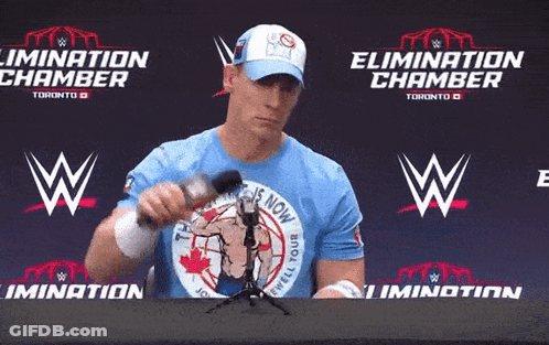 Man In Blue Shirt Saying Elimination Chamber Holding Microphone GIF