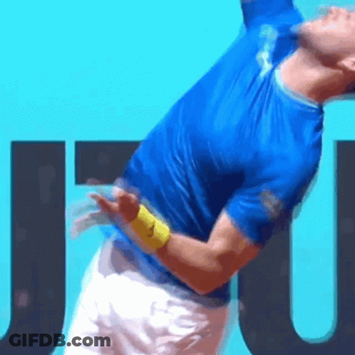 Man In Blue Shirt Serving Tennis Ball GIF