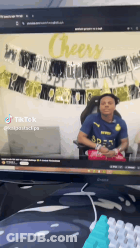 Man In Blue Shirt Sitting At Computer Saying Cheers GIF