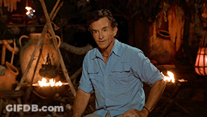 Man In Blue Shirt Sitting By Campfire GIF