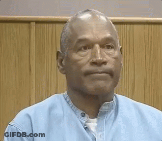 Man In Blue Shirt Sitting In Front Of Wooden Wall GIF