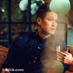 Man In Blue Shirt Sitting On Couch Holding Glass GIF