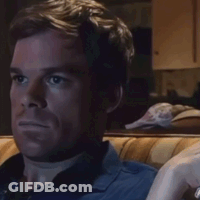 Man In Blue Shirt Sitting On Couch Looking At Something GIF